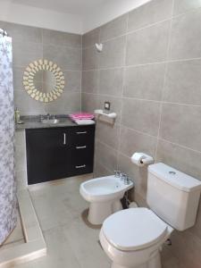 a bathroom with a toilet and a sink at Casa XENA in Río Cuarto +24 photos
