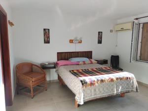 a bed in a room with a chair and a bed sidx sidx sidx at Casa XENA in Río Cuarto