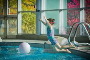 a young girl jumping into a swimming pool at 31GlenEagle Whistler in Whistler