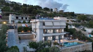 a large white house with a swimming pool at Safir Luxury Suites in Sarandë