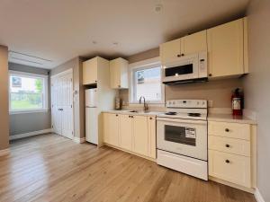 a kitchen with white appliances and wooden floors at SUMMERSIDE MOTEL &COTTAGES in Summerside