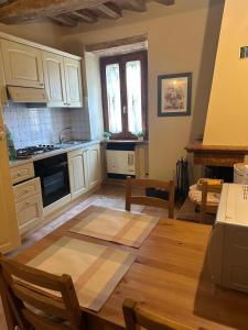 a kitchen with white cabinets and a wooden table at Casetta di Pucci in Capitone