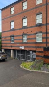 a brick building with a car parked in front of it at CJ Maison - "Spacious Family Friendly 2-Bedroom Apartment in the City Centre with free on-site parking, free Wi-Fi" in Southampton