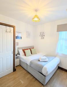 a bedroom with a large bed with a chandelier at CJ Maison - "Spacious Family Friendly 2-Bedroom Apartment in the City Centre with free on-site parking, free Wi-Fi" in Southampton
