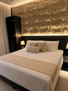 a bedroom with a white bed with a painting on the wall at Luce del sole bangalô in Fortim