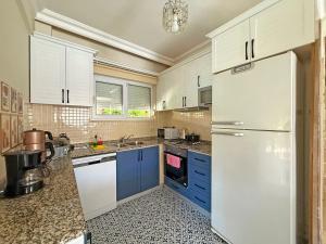 a kitchen with blue cabinets and a white refrigerator at Paradise Town Villa Orchard in Belek