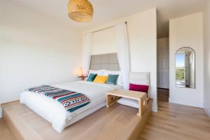a white bedroom with a bed and a chair at Shambhala Retreat-Zen Suite in Nanoose Bay