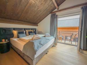 a bedroom with a large bed and a balcony at Nockberge in Afritz