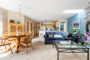 a living room with a blue couch and a table at 31GlenEagle Whistler in Whistler