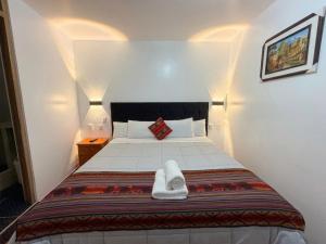 a small bedroom with a bed with two towels on it at Machu Picchu Sacred Valley in Machu Picchu