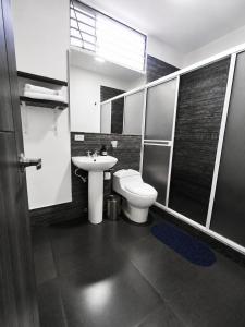a bathroom with a toilet and a sink at Hotel Siglo 21 in Cali