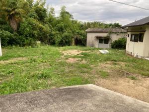 an empty yard with a house and a building at ライダーハウスみかさんち in Marugame