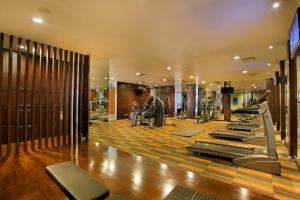 ein Fitnessstudio mit Laufbändern und Crosstrainern in der Unterkunft HARRIS Hotel & Conventions Malang in Malang