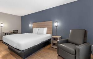 a hotel room with a bed and a chair at Extended Stay America Select Suites - Longview in Longview