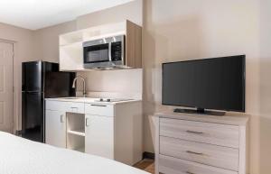 a small kitchen with a television and a refrigerator at Extended Stay America Select Suites - Longview in Longview