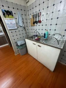 a kitchen with a sink and a wooden floor at Habitación Hostal Refugio Gaucho in Cochrane