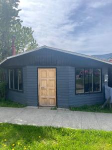 a small blue house with a wooden door at Habitación Hostal Refugio Gaucho in Cochrane