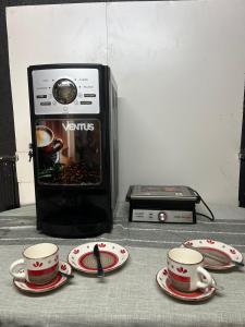 a microwave with two cups and plates on a table at Habitación Hostal Refugio Gaucho in Cochrane +1 photo