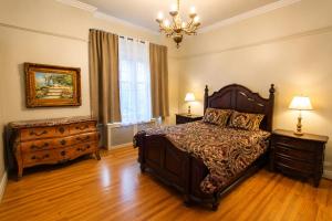 a bedroom with a bed and a chandelier at Winston Churchill - le charme Tudor au cœur de Sherbrooke in Sherbrooke