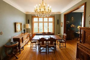 a dining room with a table and chairs and a chandelier at Winston Churchill - le charme Tudor au cœur de Sherbrooke in Sherbrooke