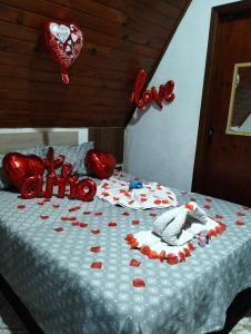 a bed with red hearts and balloons on it at Chale Rio Nascente in Salesópolis +62 photos
