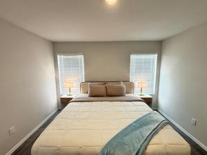 a bedroom with a large bed with two windows at Quiet at Pine Branch in Lufkin