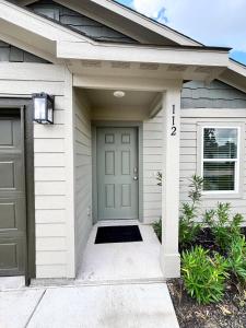 a house with a gray door and a garage at Quiet at Pine Branch in Lufkin