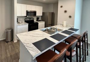 a kitchen with a counter with chairs and a counter top at Quiet at Pine Branch in Lufkin