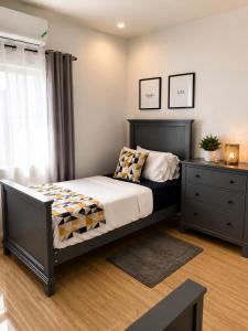 a bedroom with a bed and a dresser at Glenmuir La Ville - Gated Com May Pen in May Pen