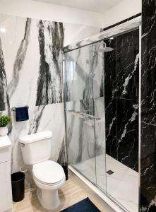 a bathroom with a toilet and a glass shower at Glenmuir La Ville - Gated Com May Pen in May Pen +12 photos