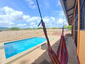 a hammock hanging from a building next to a swimming pool at Maison 3 chambres in Granada