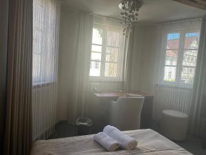 a bedroom with a bed and a desk and windows at Krone Langenburg by Ammesso in Langenburg