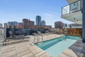 a rooftop deck with a swimming pool on a building at The Alpine City Escape in Calgary