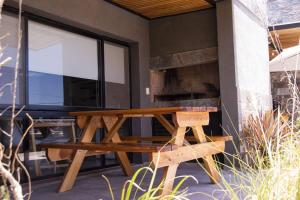 a wooden picnic table on the side of a house at Trovare un Senso in Capilla del Monte