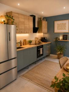 a kitchen with a stainless steel refrigerator and a table at Le Refuge de Chateau Renard in Château-Renard
