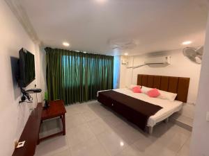 a bedroom with a bed with two pink pillows at Arlinjai Paradise in Kanyakumari