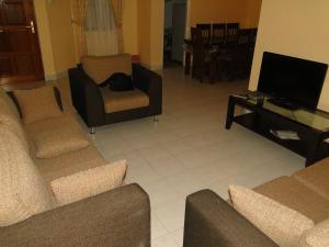 a living room with two couches and a television at BRAMA Station Court  in Colombo