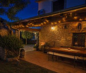 a patio with a bench and a stone wall with lights at Holiday home in Dobrinj - Insel Krk 27652 in Dobrinj +12 photos