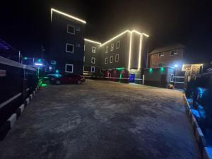 a parking lot at night with a building with lights at Emmydon Hotel And Suites in Enugu