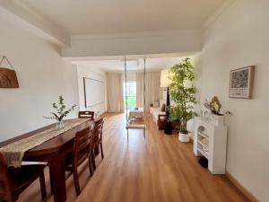 a dining room and living room with a table and chairs at Ek民宿 in Beihai