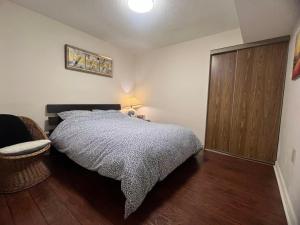 a bedroom with a bed and a wooden cabinet at Cozy Family Suite, entire place with two beds, pravite washroom and kitchen in Markham +3 photos