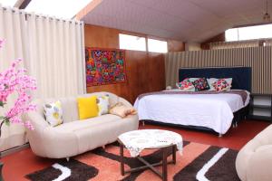 a bedroom with a couch and a bed and a couch at Titicaca Wara wara Lodge in Puno