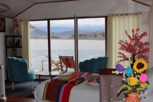 a bedroom with a bed and a view of the water at Titicaca Wara wara Lodge in Puno