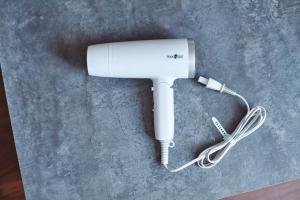 a white hair dryer with a cord plugged into it at Telegraph in Kamakura