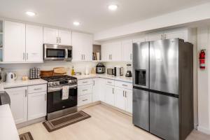 a kitchen with white cabinets and a stainless steel refrigerator at Seasons at Leschi Hillsides in Seattle +30 photos