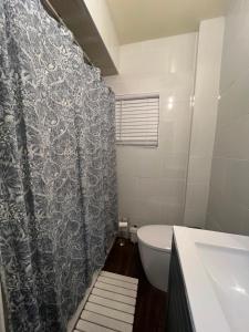 a bathroom with a toilet and a shower curtain at Cerca de Nueva York, Confortable in West New York +5 photos