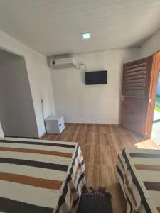 a living room with a flat screen tv on the wall at Chalés Brisa do Mar in Amontada