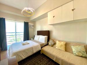 a bedroom with a bed and a couch at The Loop North Tower in Cagayan de Oro