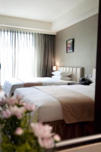 Cette chambre comprend 2 lits et une fenêtre. dans l'établissement Urban Hotel33, à Kaohsiung