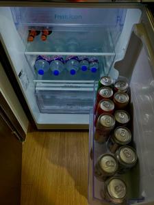 an open refrigerator with cans of food in it at The Loop North Tower in Cagayan de Oro